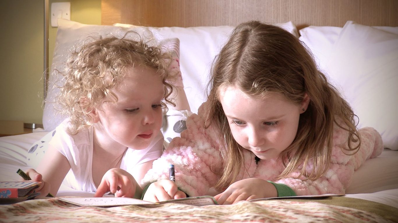 Kids colouring on bed