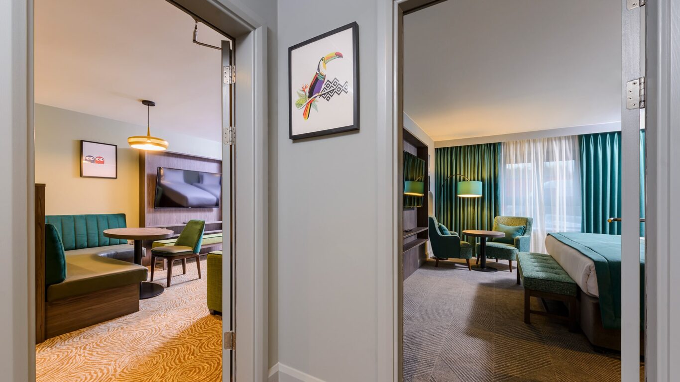 Modern hotel suite with elegant seating, plush d&eacute;cor, and inviting lighting, offering a relaxing and stylish stay.