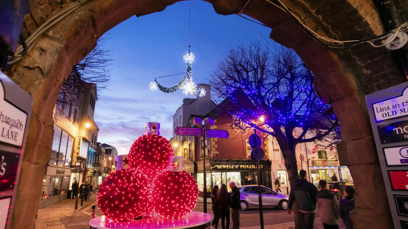 Experience a festive evening stroll in Killarney, Ireland, with glowing holiday lights, charming shops, and lively streets.