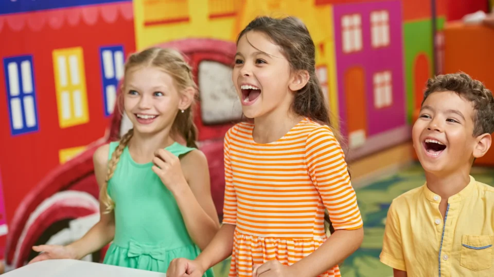 Happy children enjoying colourful hotel children's play area.