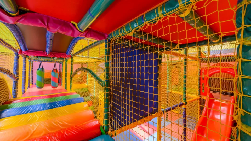 Colourful indoor soft play area with slides and climbing nets, perfect for children's fun and adventure at our family-friendly hotel.