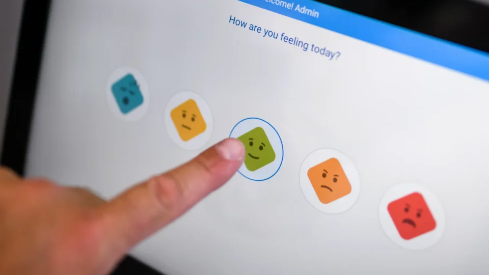 Guest feedback touch screen with smiley faces for hotel experience rating.