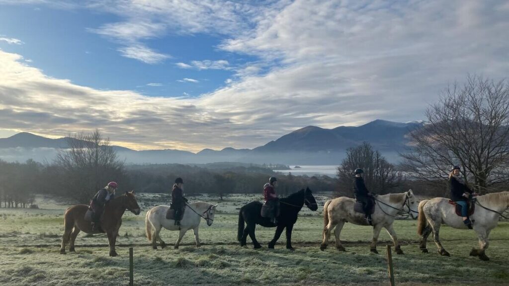 Guests enjoy horse riding with stunning mountain and lake views on a crisp morning near the hotel.